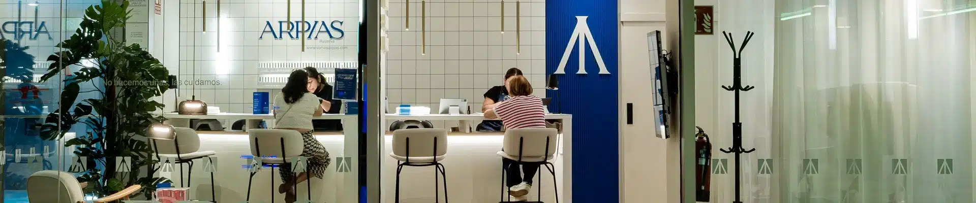 Salón de manicura y cuidado de uñas Arpias en el centro comercial Aragonia, con la barra de manicura atendiendo a clientas y el logotipo de la marca