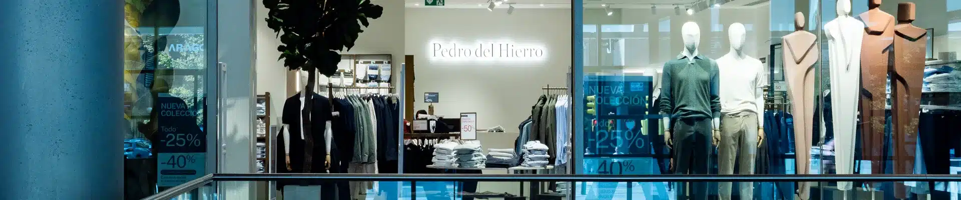 Interior de la tienda de moda Pedro del Hierro en el centro comercial Aragonia, con maniquíes vestidos, percheros de ropa de hombre y la nueva colección