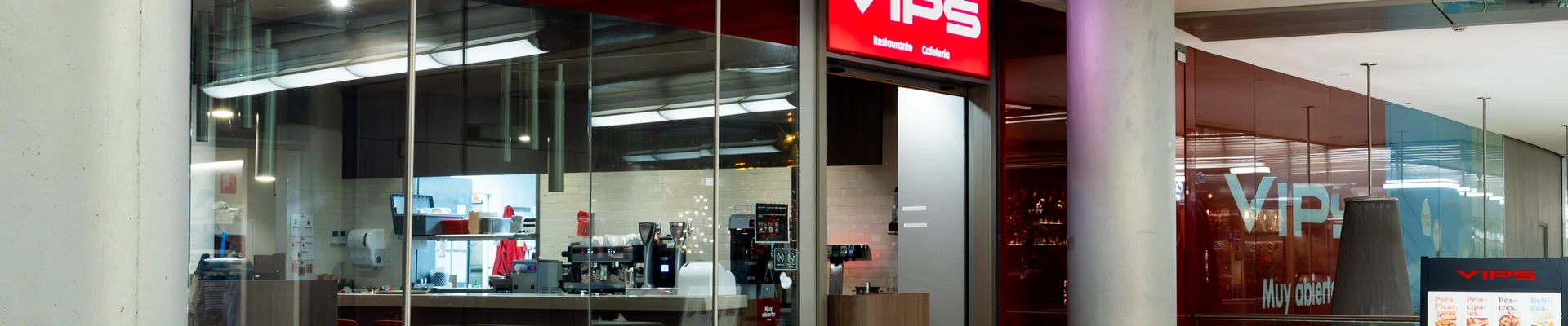 Restaurante y cafetería VIPS en el centro comercial Aragonia, con el rótulo rojo, la barra de cafetería con las máquinas de café y la carta