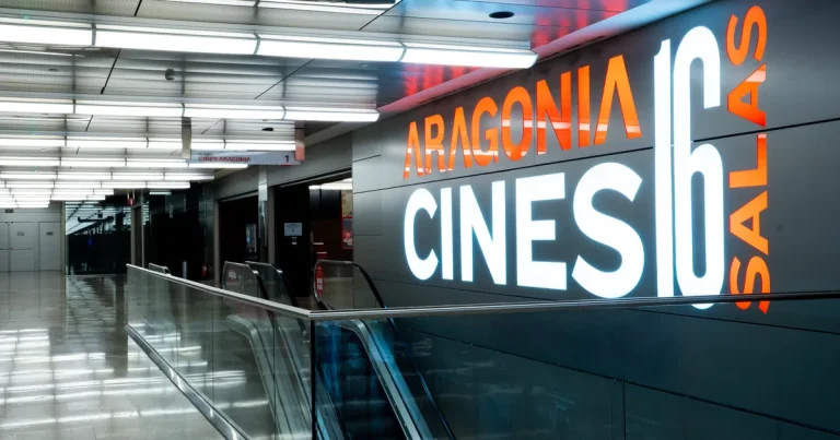 Entrada a Cines Aragonia con el rótulo iluminado de 16 salas junto a las escaleras mecánicas del centro comercial Aragonia en Zaragoza